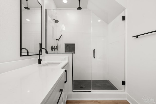 bathroom with a shower with shower door and vanity