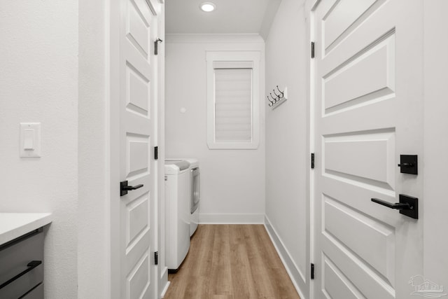 laundry area featuring washer and clothes dryer and light hardwood / wood-style flooring