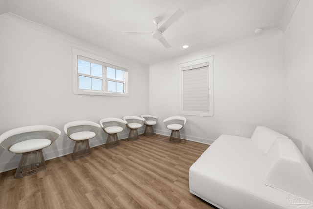 living area with hardwood / wood-style flooring, crown molding, and ceiling fan