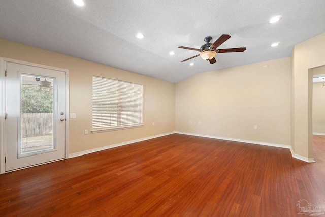 empty room with hardwood / wood-style flooring, ceiling fan, lofted ceiling, and a textured ceiling