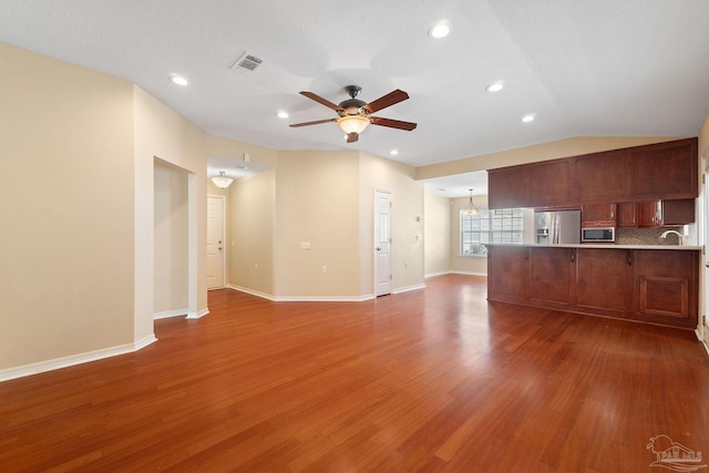 unfurnished living room with ceiling fan, dark hardwood / wood-style flooring, and vaulted ceiling