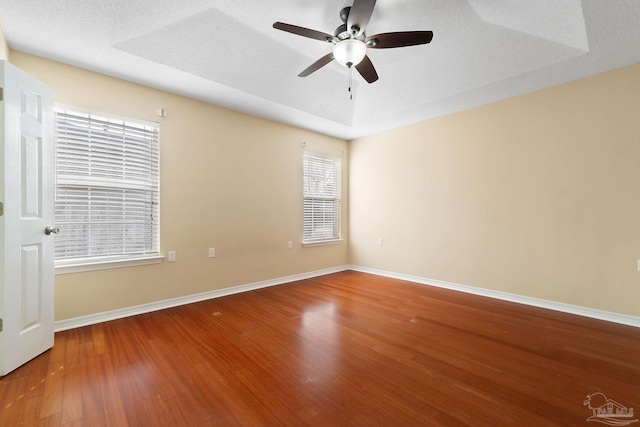 empty room with ceiling fan, hardwood / wood-style flooring, and a textured ceiling