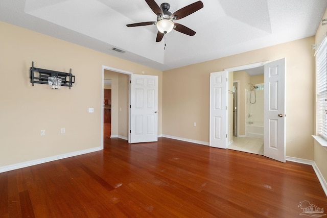 unfurnished bedroom featuring ensuite bath, wood-type flooring, and ceiling fan