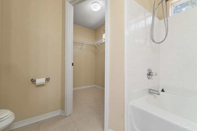 bathroom with a textured ceiling, tile patterned floors, and toilet