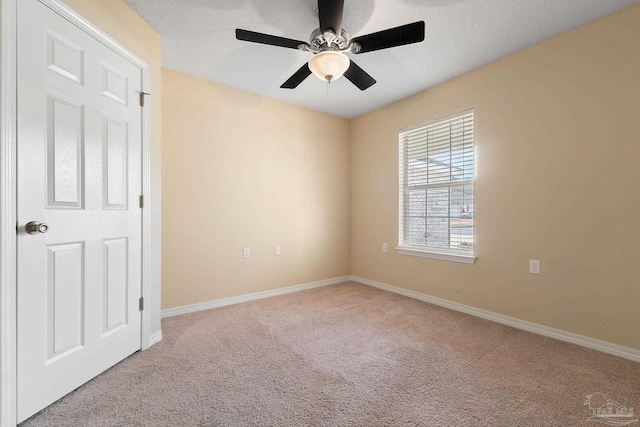 unfurnished room with ceiling fan, light colored carpet, and a textured ceiling