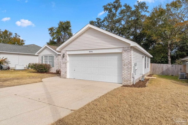 ranch-style house featuring a garage, a front lawn, and central air condition unit