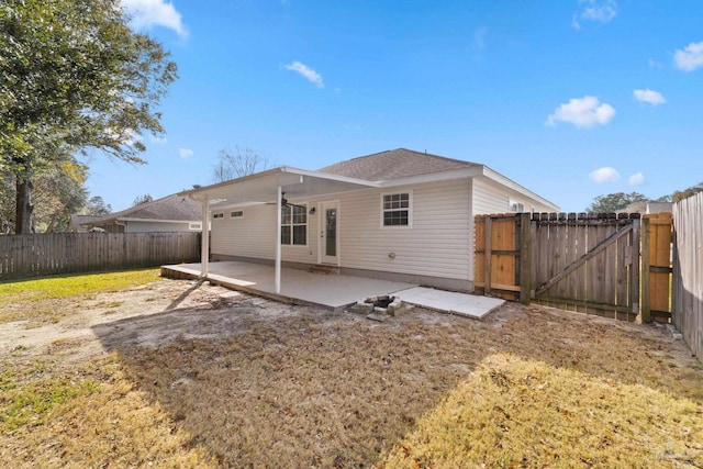 back of house with a yard and a patio