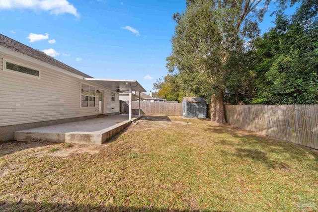 view of yard with a patio, ceiling fan, and a storage shed