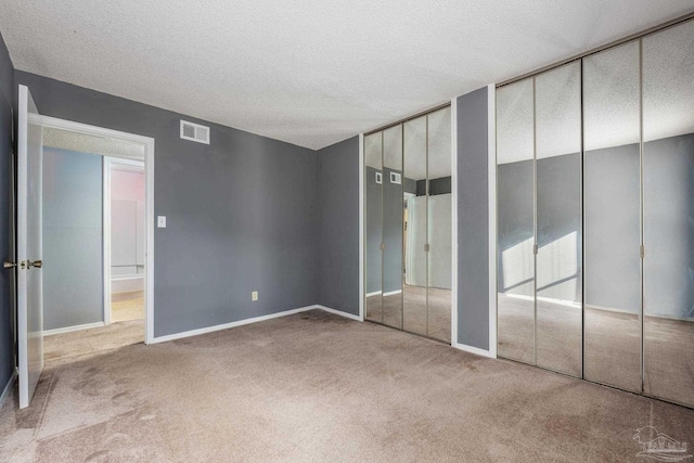 2201 Scenic Hwy Unit M1, Pensacola, FL 32503 - unfurnished bedroom featuring carpet, two closets, a textured ceiling, and baseboards