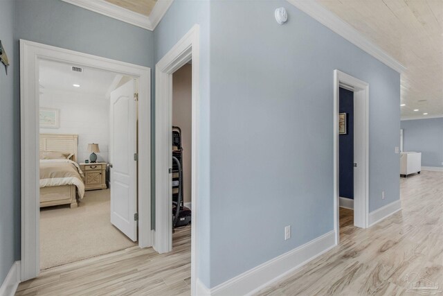 corridor featuring light wood-type flooring and ornamental molding