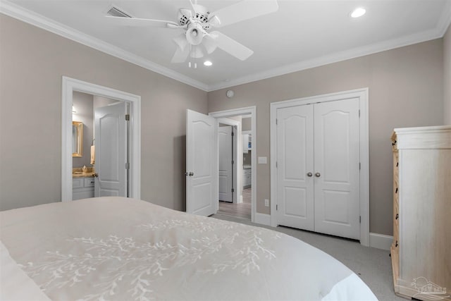 carpeted bedroom with ceiling fan, ensuite bathroom, ornamental molding, and a closet