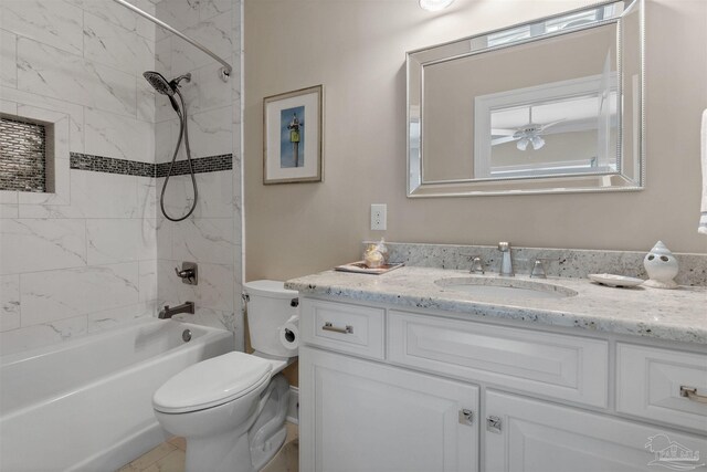 full bathroom featuring toilet, vanity, ceiling fan, and tiled shower / bath