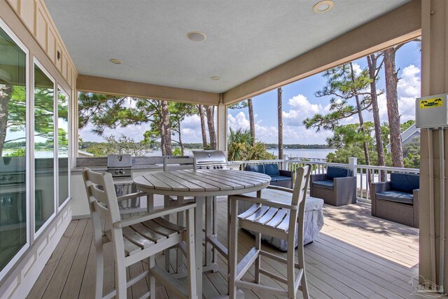 sunroom featuring a water view