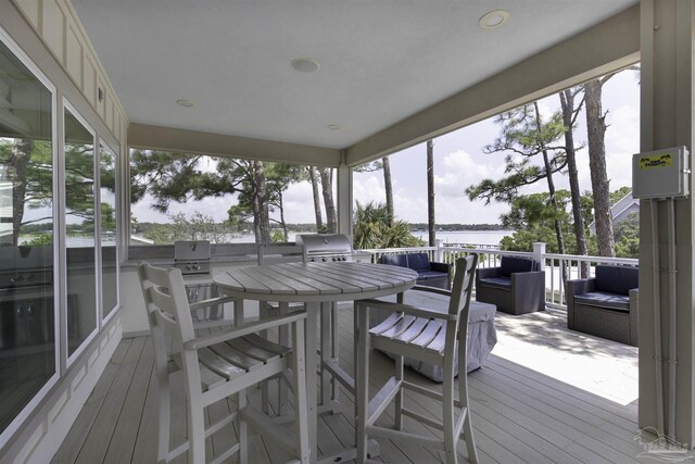 sunroom / solarium featuring a water view