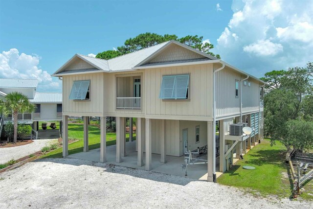 view of front of home featuring a front yard, central air condition unit, and a carport