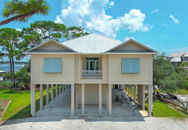 view of front facade featuring a front lawn, a water view, and a carport