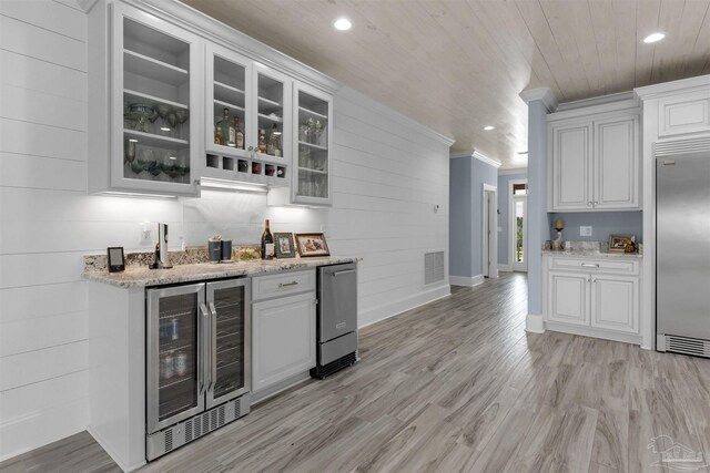 kitchen with light hardwood / wood-style flooring, ornamental molding, beverage cooler, and built in fridge