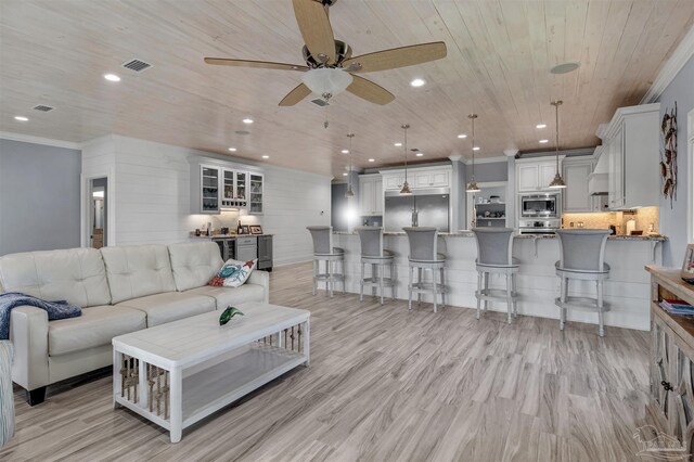 living room with wooden ceiling, ceiling fan, light wood-type flooring, and ornamental molding