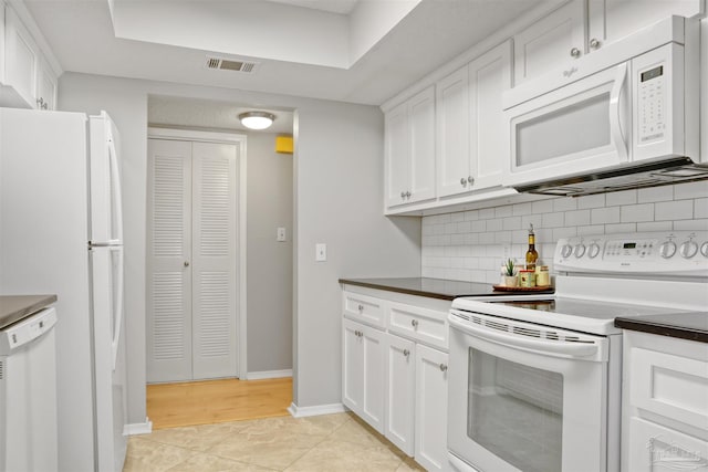 kitchen with white appliances, visible vents, white cabinets, backsplash, and dark countertops