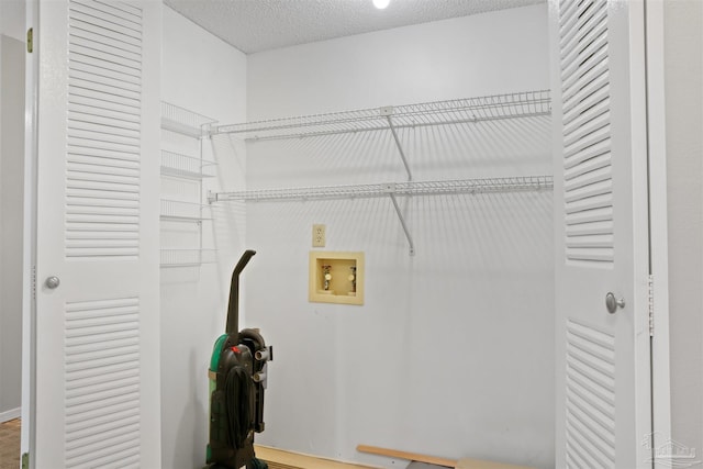 washroom featuring laundry area, washer hookup, and a textured ceiling