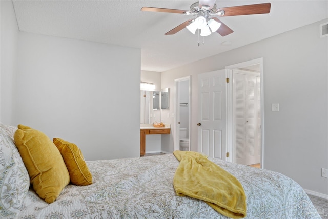 bedroom with visible vents, ensuite bathroom, a ceiling fan, carpet flooring, and baseboards