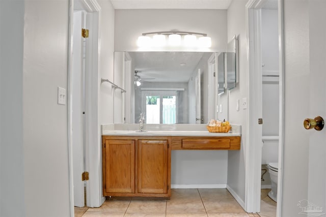 bathroom featuring baseboards, a ceiling fan, toilet, tile patterned floors, and vanity