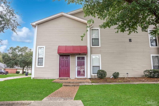 townhome / multi-family property featuring a front lawn