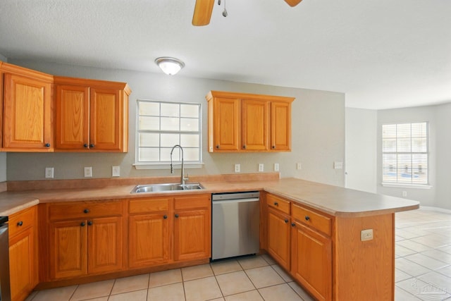 kitchen with a sink, a peninsula, dishwasher, and a healthy amount of sunlight