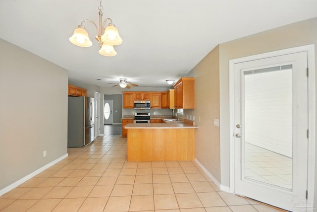 kitchen featuring appliances with stainless steel finishes, light countertops, light tile patterned floors, baseboards, and a peninsula