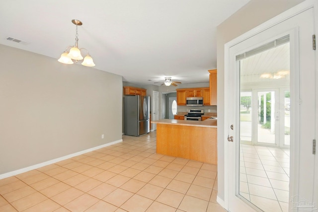 kitchen with visible vents, a peninsula, light countertops, light tile patterned floors, and stainless steel appliances