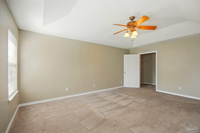 unfurnished bedroom with baseboards, a ceiling fan, light carpet, and multiple windows