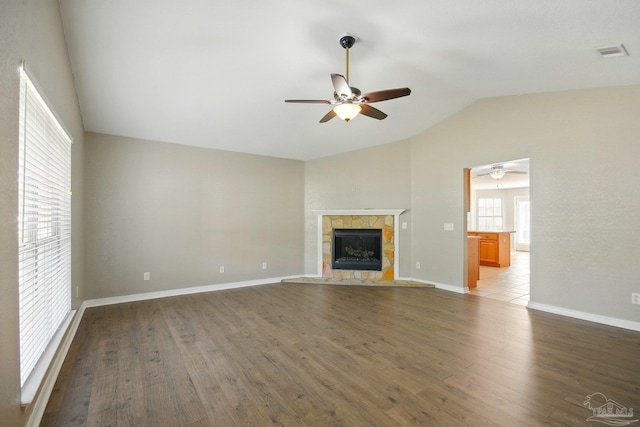 unfurnished living room featuring a ceiling fan, visible vents, a fireplace, wood finished floors, and lofted ceiling