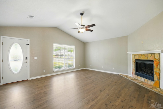 unfurnished living room featuring ceiling fan, a fireplace, wood finished floors, and lofted ceiling