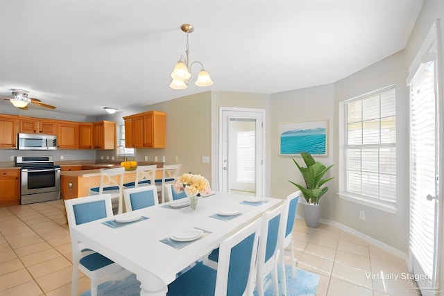 dining space featuring baseboards, light tile patterned flooring, and a chandelier