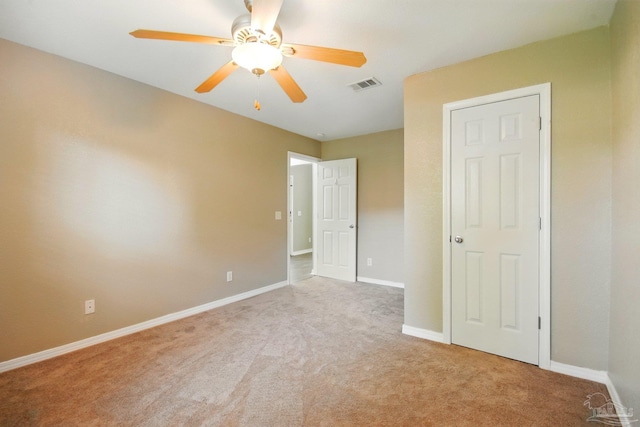 unfurnished bedroom with light colored carpet, baseboards, visible vents, and ceiling fan