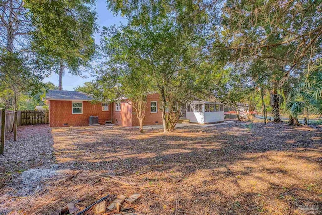 view of yard featuring a sunroom and central AC