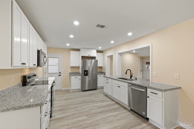 kitchen with white cabinets, sink, appliances with stainless steel finishes, and light hardwood / wood-style flooring