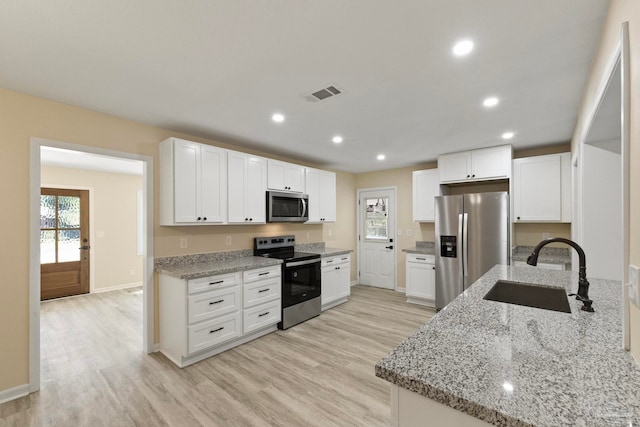 kitchen featuring sink, white cabinets, stainless steel appliances, and light hardwood / wood-style floors