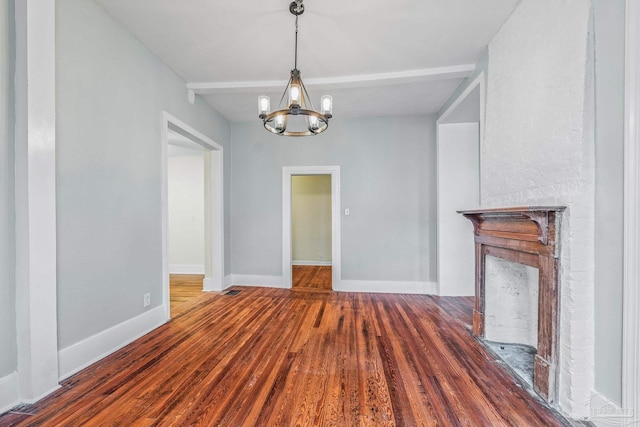 unfurnished dining area featuring an inviting chandelier, beam ceiling, and wood-type flooring