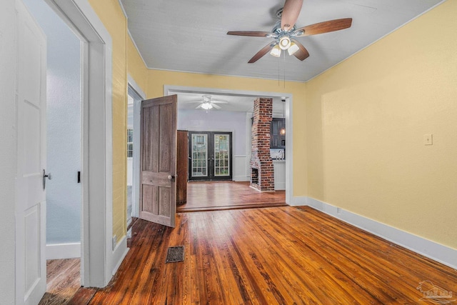 spare room featuring ceiling fan, dark hardwood / wood-style flooring, and decorative columns