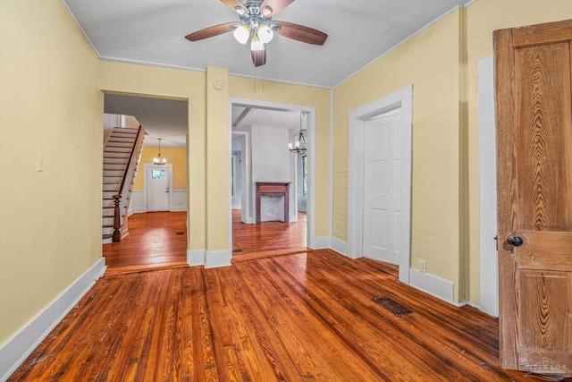 interior space with ceiling fan with notable chandelier and wood-type flooring