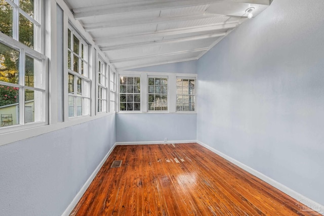 unfurnished sunroom featuring lofted ceiling with beams