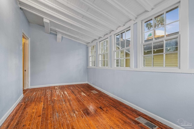 unfurnished sunroom with vaulted ceiling with beams