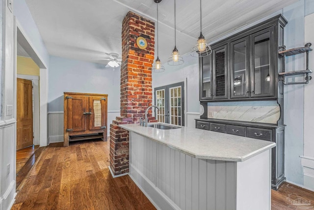 kitchen featuring dark hardwood / wood-style floors, sink, hanging light fixtures, ceiling fan, and french doors