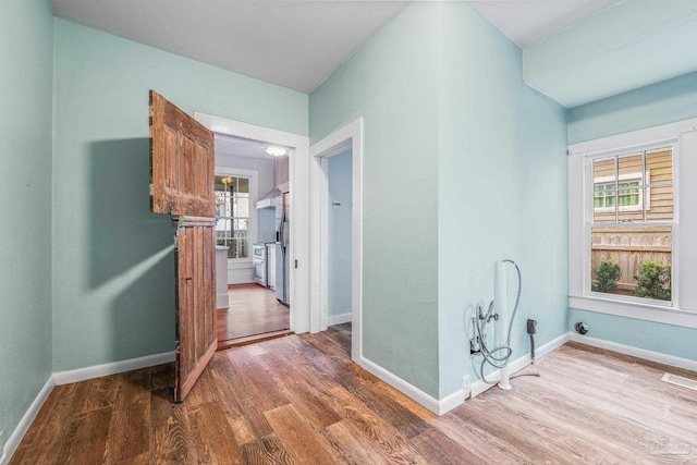 hallway with hardwood / wood-style floors and a wealth of natural light