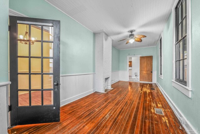 spare room with ceiling fan, hardwood / wood-style floors, and a brick fireplace