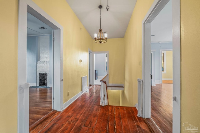 hallway featuring dark wood-type flooring and a chandelier