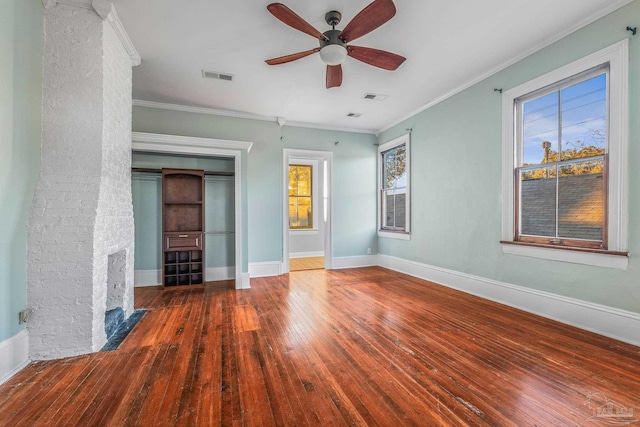 unfurnished bedroom featuring crown molding, ceiling fan, dark wood-type flooring, and a brick fireplace