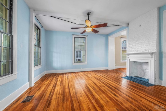 unfurnished living room featuring ceiling fan, hardwood / wood-style floors, and a brick fireplace