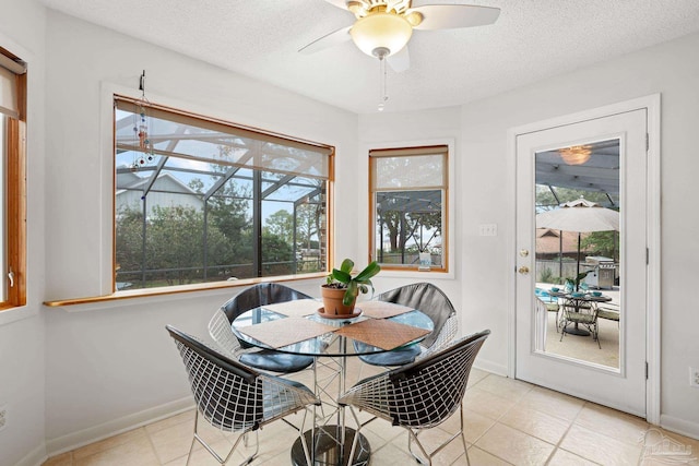 dining room featuring a sunroom, plenty of natural light, and a textured ceiling